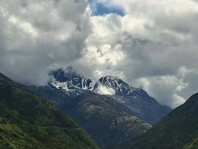 Snow-covered Alaskan peaks half hidden in low cloud