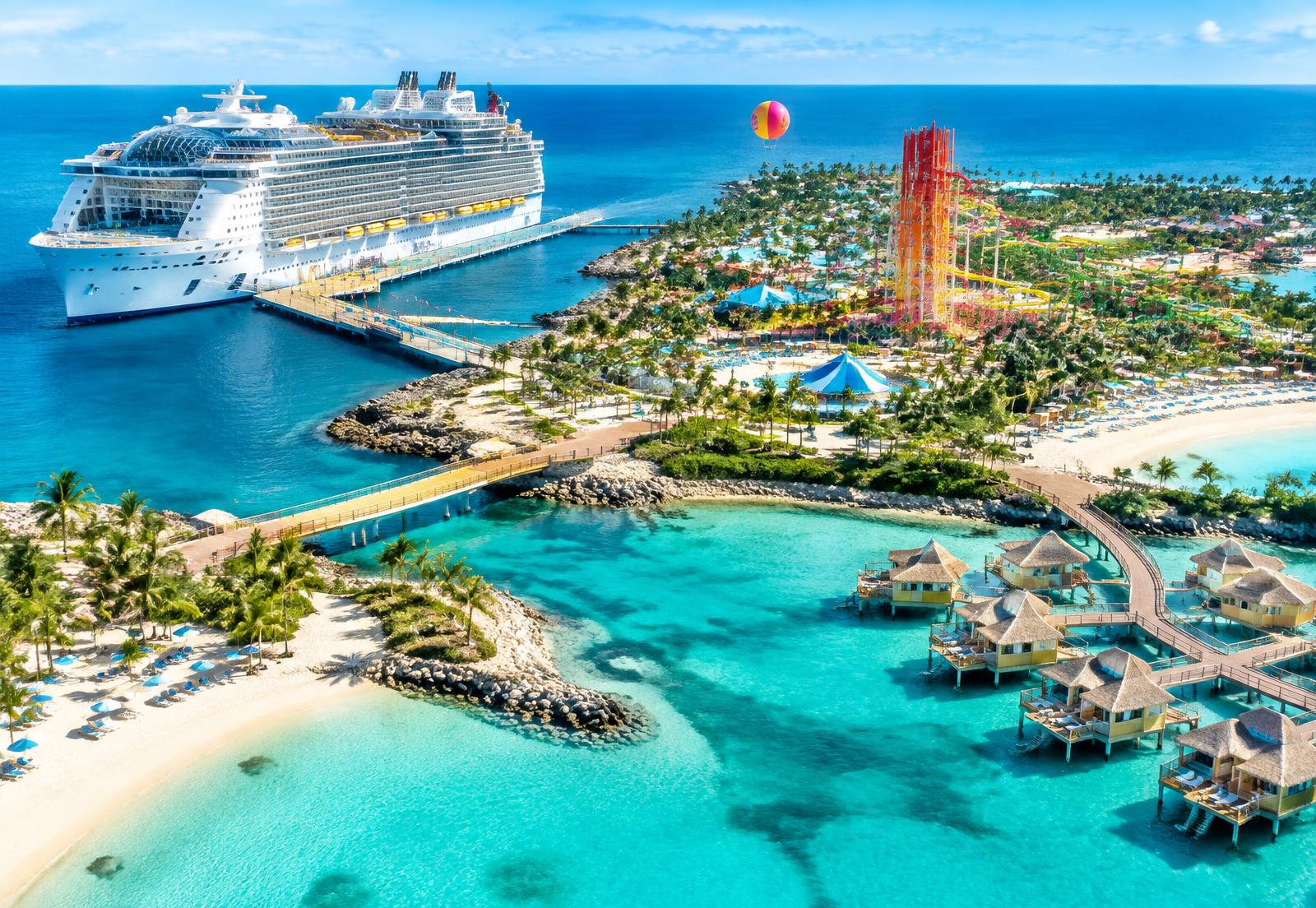 A modern cruise ship beside a vibrant private island and colorful waterpark