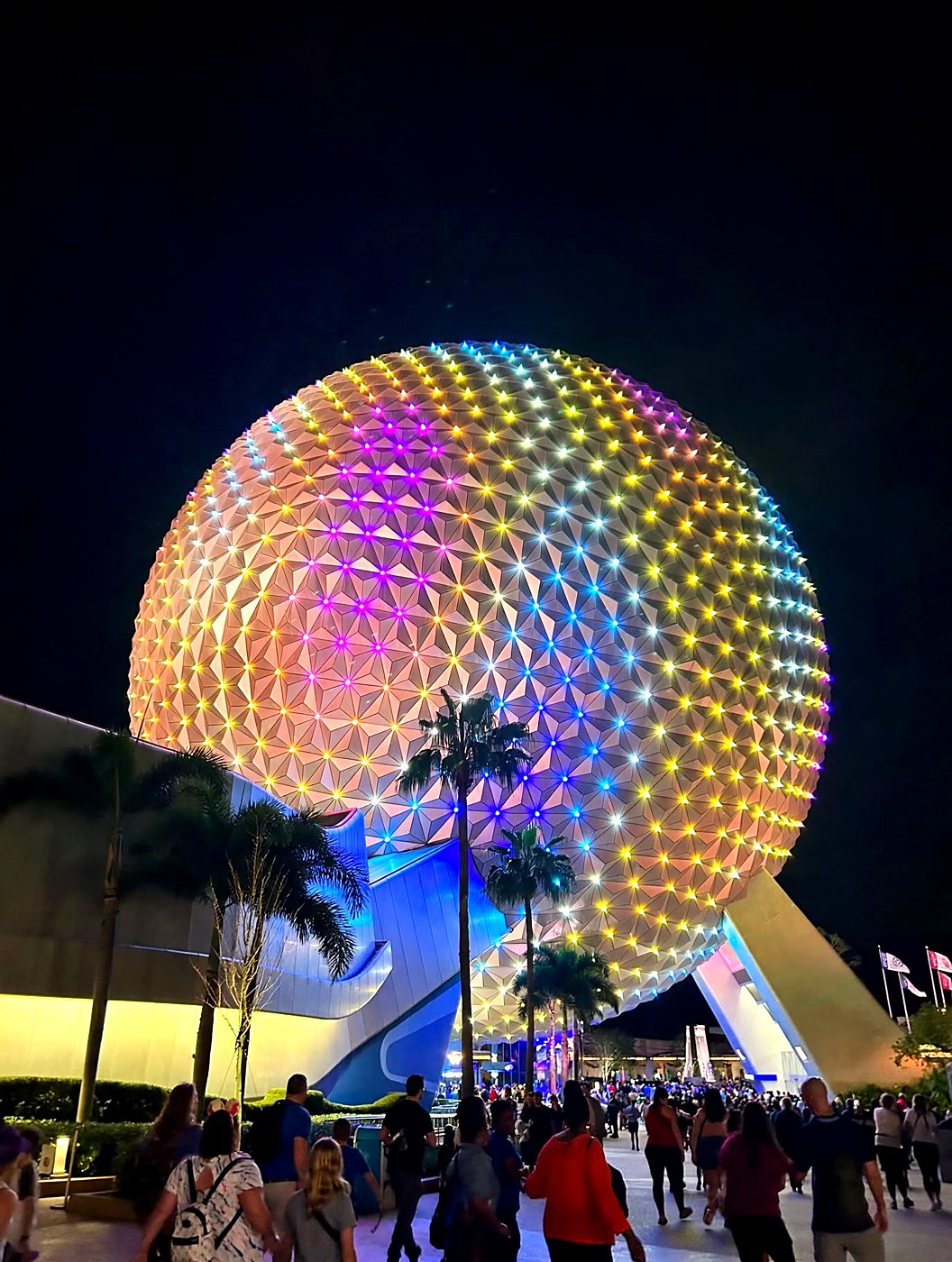 EPCOT's sphere glowing with colorful lights at night, photographed by Jennifer